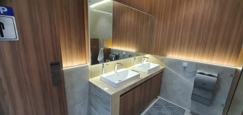 Twin-basin washroom vanity with timber cabinetry and concealed lighting at Flextronics PTP
