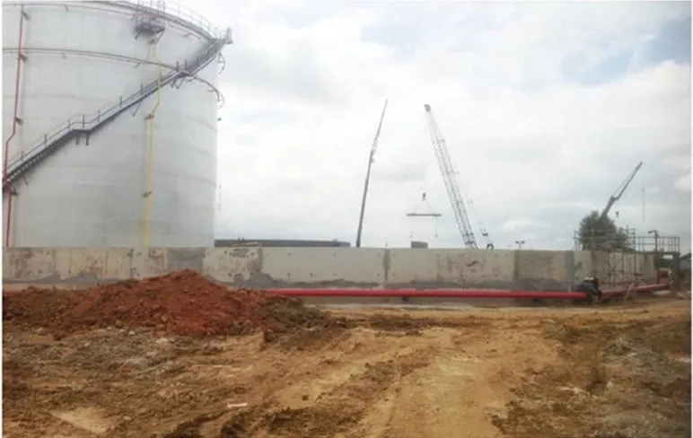 Cast concrete retaining wall running beside a storage tank on the Lotte Chemical Titan site, Pasir Gudang