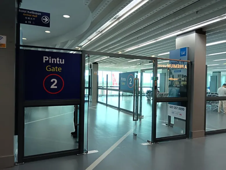 Glazed boarding gate opening onto the refurbished departure seating area at Senai Airport