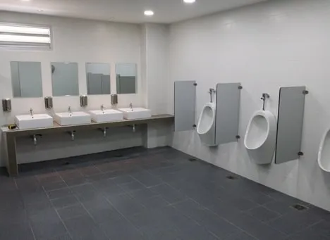 Renovated public washroom at Senai Airport with wall-mounted basins, urinals and mirrors