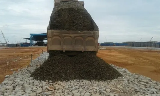 Aggregate being laid over the stone road base under construction at Pengerang, Kota Tinggi