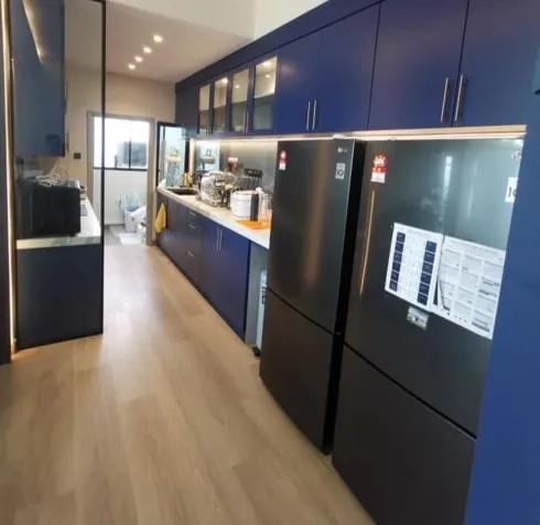 Galley kitchen with deep navy cabinetry and under-cabinet lighting in a Taman Molek residence